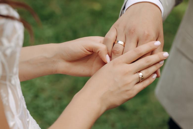 Couple holding hands to show matching rings
