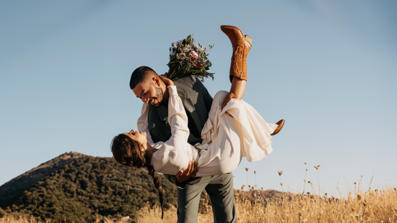happy groom holding bride
